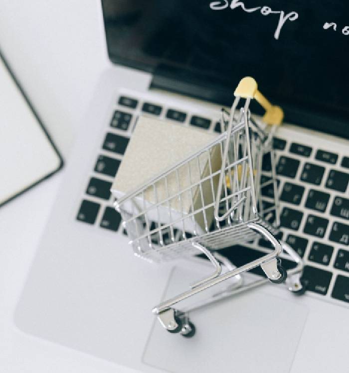 A small shopping cart next to a laptop keyboard